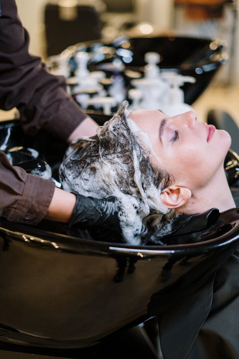 Femme utilisant un lisseur professionnel sur ses cheveux devant un miroir