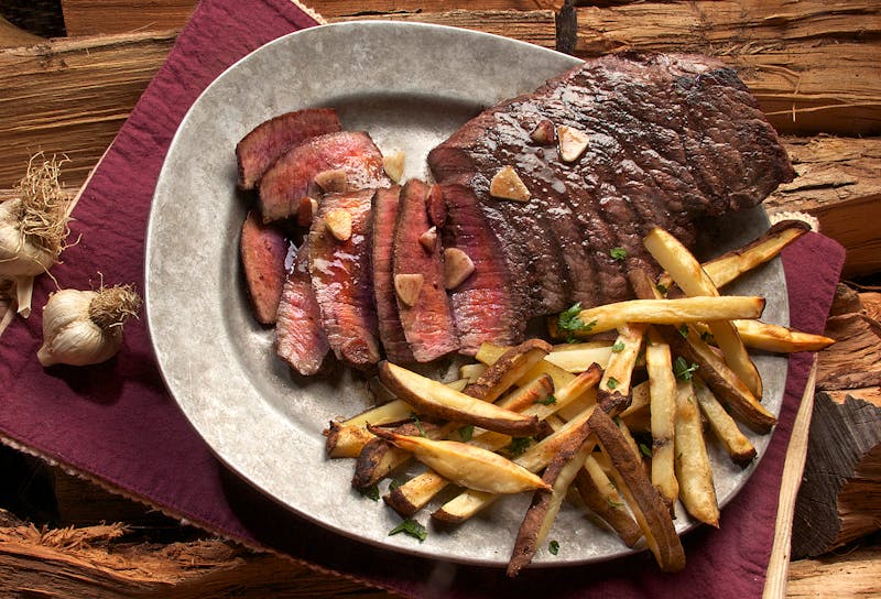 Rôti de porc doré et juteux sorti du four accompagné de pommes de terre rôties et de légumes
